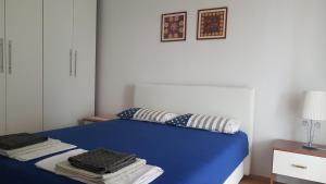 a bedroom with a blue bed with pillows on it at Apartment Stiller in Novalja