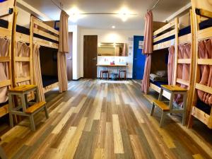 a room with two bunk beds and a kitchen at Guest House Matsu in Osaka