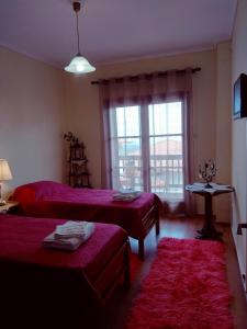 a hotel room with two beds and a window at Sofia's House in Litochoro