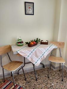 uma mesa com duas cadeiras e uma tigela de fruta em Sofia's House em Litochoro