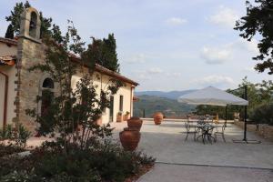 a patio with a table and a white umbrella at Borgo di Villa Cellaia Apartments with pool & SPA in Dicomano