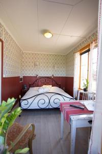 a bedroom with a bed and a table in it at Prinsgården B&B rum stugor in Mora
