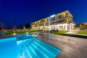 a building with a swimming pool at night at Vision Hotel in Peschiera del Garda