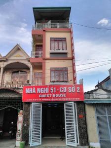 
a red brick building with a sign on the side of it at Guesthouse 51 in Diện Biên Phủ
