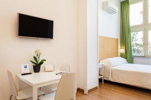 um quarto com uma secretária e uma cama e um quarto com uma televisão em Corso Italia Suites em Sorrento