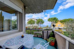 un patio con tavolo e sedie sul balcone. di DesenzanoLoft Il girasole del Lago a Desenzano del Garda