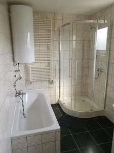 a bathroom with a shower and a tub and a sink at Ferienwohnung 123 in Fohnsdorf