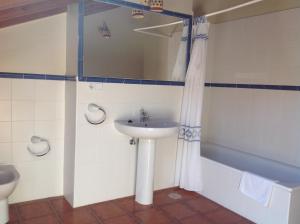 a bathroom with a sink and a toilet and a mirror at Casa de la Tila in Arenas de Cabrales +40 photos