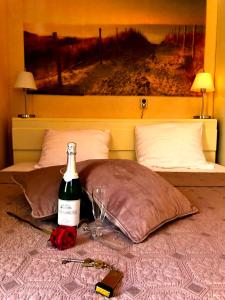 a bottle of wine and two glasses on a bed at Mare Sanat in Wijk aan Zee