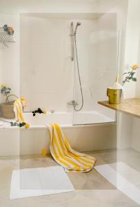 een witte badkamer met een bad en een handdoek op de vloer bij Hotel Sonnalm in Bad Kleinkirchheim
