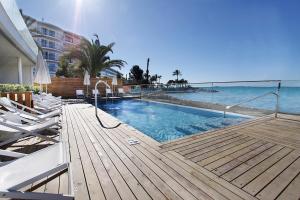 a swimming pool with chairs and the ocean at BG Nautico Ebeso in Ibiza Town