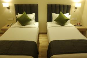 A bed or beds in a room at Regenta Central Harsha Vapi