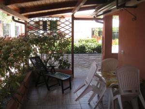 a patio with chairs and a table and a table and chairs at Casa Vacanze Mimose in Palinuro