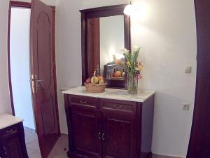 a bathroom with a vanity with a mirror and a basket of fruit at Eleni Apts in Kamilari +75 photos