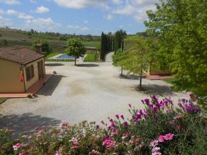 a gravel driveway with a building and flowers at Agriturismo Barbarino in Vinci