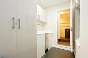 a kitchen with white cabinets and a glass door at Apartments At Marylebone in London