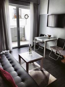 a living room with a couch and a table at Apartament Orchidea New Slavia in Międzyzdroje