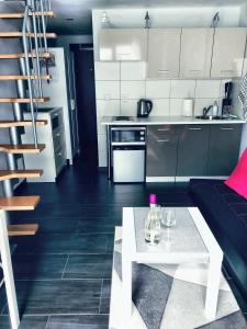 a kitchen and a living room with a couch and a table at Apartament Orchidea New Slavia in Międzyzdroje