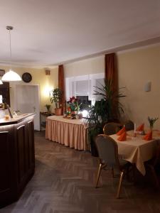 a room with a table and chairs and a kitchen at Hotel & Pension Aßmann in Hochkirch