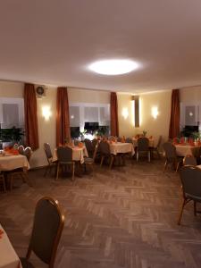 ein Esszimmer mit Tischen, Stühlen und einer Decke in der Unterkunft Hotel & Pension Aßmann in Hochkirch
