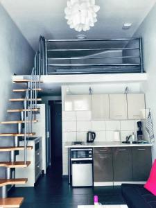 a kitchen with a spiral staircase in a room at Apartament Orchidea New Slavia in Międzyzdroje