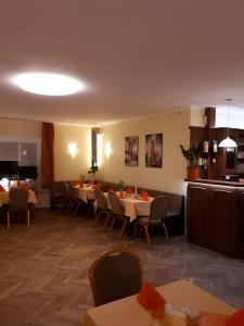 Hotel & Pension Aßmann في Hochkirch: مطعم فيه طاولات وكراسي في الغرفة