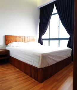 een slaapkamer met een groot bed en een raam bij Mahkota Seaview Condo Homestay Near A'Famosa jonker Melaka in Melaka