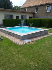 a swimming pool with two faucets in a yard at Hotel & Pension Aßmann in Hochkirch