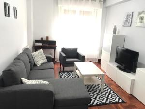 a living room with a couch and two chairs and a television at ZARAUTZ CENTRO Garaje-Parking-Free in Zarautz