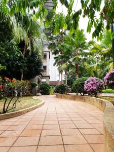 een loopbrug in een park met bomen en bloemen bij Mahkota Seaview Condo Homestay Near A'Famosa jonker Melaka in Melaka