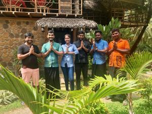 a group of men praying in front of a house at Wind Blend Kite Resort in Kalpitiya
