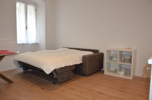 łóżko w pokoju ze stołem i oknem w obiekcie Appartamento Sunrise - Centro Storico N1 w mieście Riva del Garda