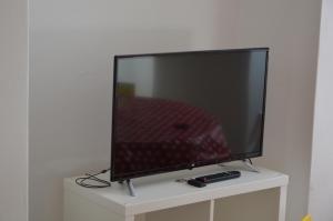 telewizor z płaskim ekranem siedzący na białej szafce w obiekcie Appartamento Sunrise - Centro Storico N1 w mieście Riva del Garda