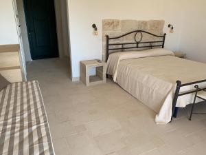 a bedroom with two beds and a tiled floor at BioAgriturismo Messer Gesualdo in Nociglia