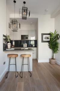 een keuken met 2 barkrukken en een aanrecht bij Holyrood Park City Centre Apartment in Edinburgh