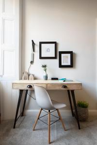 a desk with a white chair in a room at Holyrood Park City Centre Apartment in Edinburgh