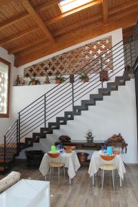 un comedor con 2 mesas y una escalera en Corte Nuova B&B, en Bagnolo San Vito