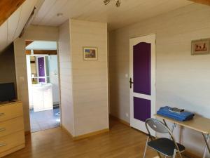 Habitación con mesa y puerta morada en La Ferme de Genarville, en Bouville