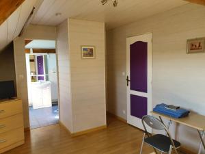 a room with a table and a purple door at La Ferme de Genarville in Bouville