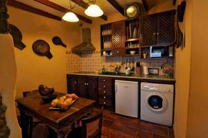 Casa abuela Amparo في فرونتيرا: مطبخ مع طاولة وغسالة ملابس