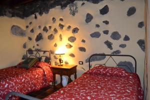 2 camas en una habitación con rocas en la pared en Casa abuela Amparo en Frontera