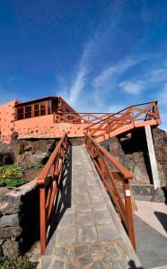un puente de madera con un edificio en la cima de una montaña en Casa abuela Amparo, en La Frontera