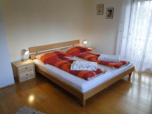 - une chambre avec 2 lits et des couvertures rouges et oranges dans l'établissement Apartment Ferienwohnung Kogler, à Kraig