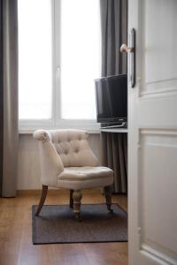 a living room with a chair and a television at Restaurant & Guesthouse Cachet de Cire in Turnhout