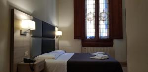 a bedroom with a bed and a stained glass window at Hotel Desirèe in Florence