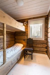 a bedroom with a bed and a chair and a window at Mountain View in Stranda