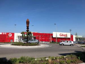 a parking lot with cars parked in front of a car dealership at Comfort Stay Basel Airport 1B46 in Saint-Louis