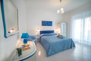 Un dormitorio con una cama azul y una mesa en B&B Amalba Maiori, en Maiori