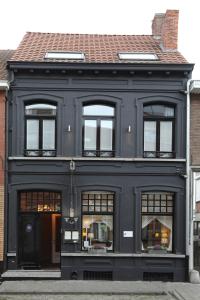 ein schwarzes Gebäude mit Fenstern in der Unterkunft Restaurant & Guesthouse Cachet de Cire in Turnhout