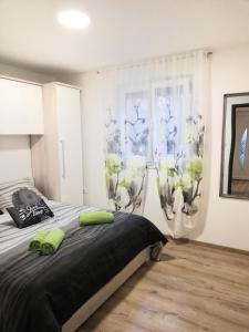 a bedroom with a bed with green pillows on it at Apartments MTV - private parking, Fast Wi-Fi & Steps to the Beach in Zadar